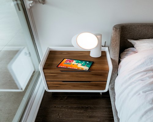 Man putting away his smartphone on a nightstand